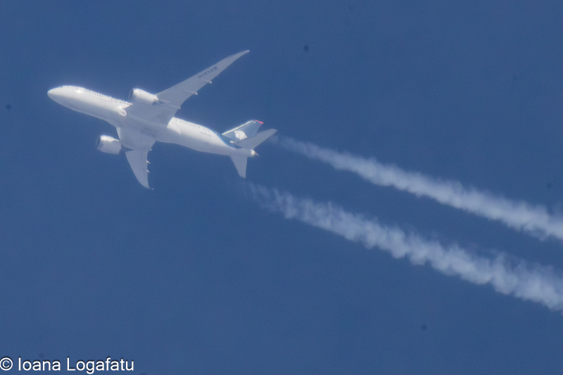Flying high with trails across the clear blue sky